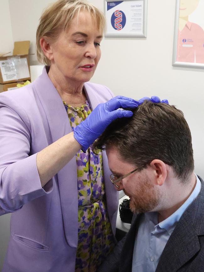 Ros Bates, a former nurse, examines Guardian journalist Andrew Messenger’s scalp after he split his head open entering an election campaign press conference in central Queensland. Picture: Liam Kidston.