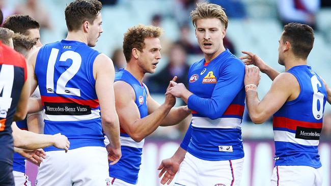 Mitch Wallis celebrates a goal with Bulldogs teammates.