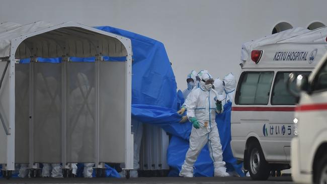 Medical staff clad in protective gear prepare to provide care for suspected coronavirus patients onboard the quarantined Diamond Princess cruise ship at Daikoku Pier Cruise Terminal in Yokohama on Saturday.