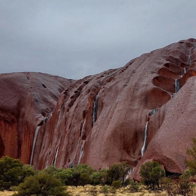 Waterfalls appeared at Uluru on Monday, as a flood watch is issued for Central Australia. Photo: Geigbe_the_Van.