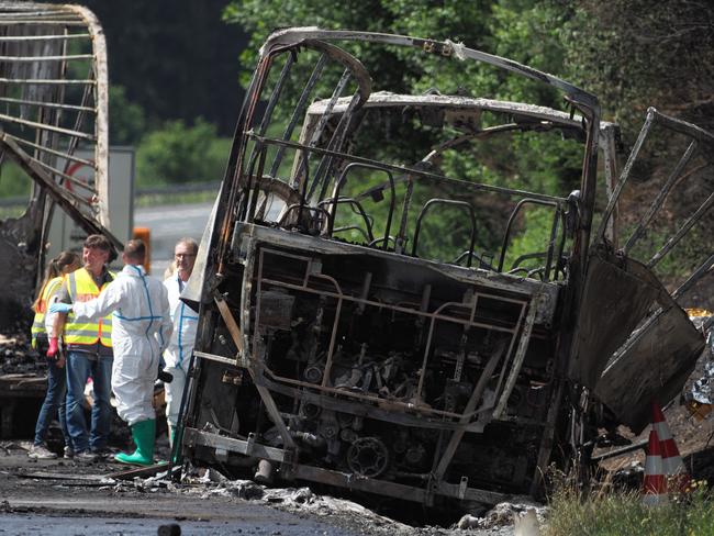 Fire fighters and rescuers stand beside a burnt-out bus on a highway near Muenchberg, southeastern Germany. Picture: Nicolas Armer/dpa via AP