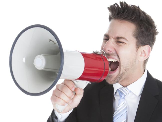 Full length of young businessman screaming into megaphone over white background