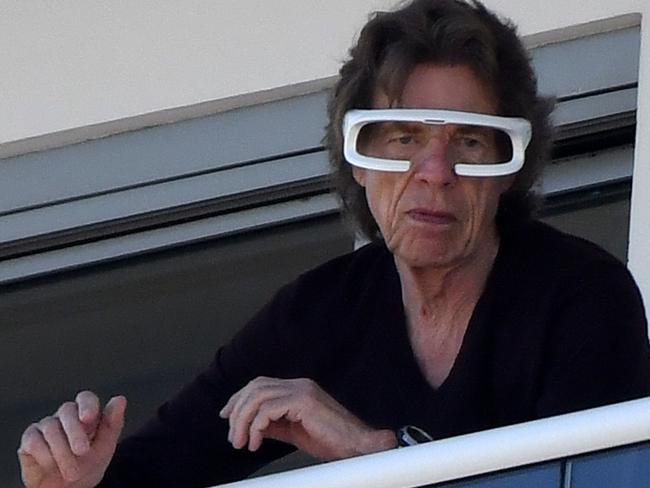 PREMIUM EXCLUSIVE: Rolling Stones front man Mick Jagger is seen wearing light therapy glasses and using an electric shaver as he hangs out with girlfriend Melanie Hamrick on their hotel balcony in Miami.The futuristic looking glasses cast a blue light over the eyes and onto the face.They are used for a variety of reasons, including helping to relieve jet lag symptoms such as insomnia, sleepiness, and physical and fatigue. Light therapy is also a way to treat seasonal affective disorder (SAD) and certain other conditions, such as depression, anxiety and chronic pain, by exposure to artificial light. Later in the day, the rocker, 78, kicked off his shoes and donned a straw hat and shades as he made the most of his downtime before once again wowing on stage. 23 Nov 2021 Pictured: Mick Jagger; Melanie Hamrick. Photo credit: MEGA TheMegaAgency.com +1 888 505 6342 (Mega Agency TagID: MEGA808009_001.jpg) [Photo via Mega Agency]