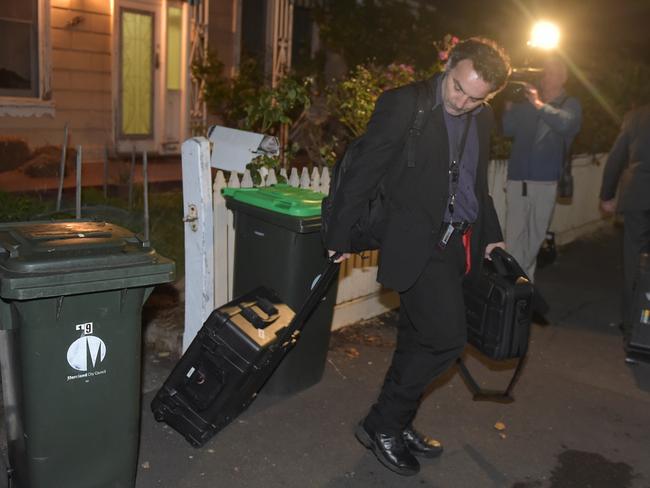 AFP officers leave the Brunswick property. Picture: Jay Town