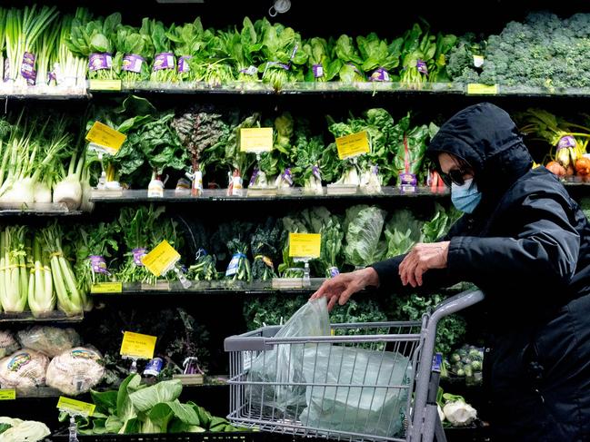 A shopper wears a protective mask at a grocery store in Washington, DC, on February 19, 2022. - Mayor Muriel Bowser announced the US capital was dialing back its indoor mask requirement on March 1. Masks will not be required at restaurants and bars, sports and entertainment venues, gyms, recreation centers, indoor athletic facilities, houses of worship, businesses, grocery stores and pharmacies, retail establishments and DC government offices that don't have direct contact with the public. (Photo by Stefani Reynolds / AFP)