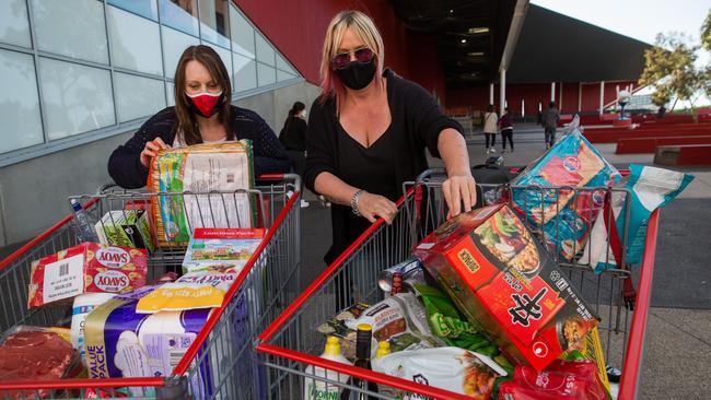 Leah Birch and Laura Kretuik stock up as a huge lines of shoppers queue to enter Costco in Docklands. Picture: Paul Jeffers