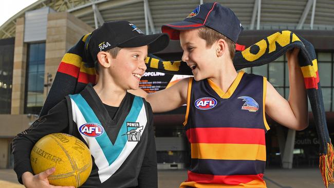 Eight-year-old twins Charlie (Port Adelaide) and Henry Adams (Adelaide) are excited that footy is returning – with fans in the ground. Picture: Tom Huntley