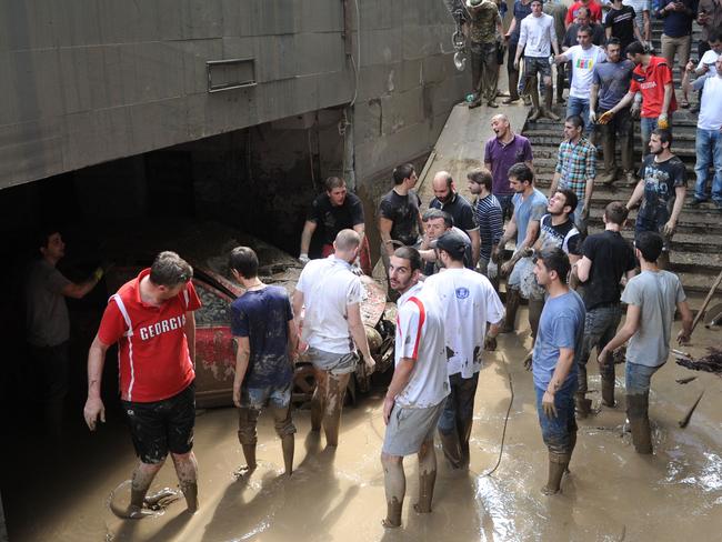 After the deluge ... Local residents try to evacuate a car as floods hit the Georgian capital of Tbilisi after zoo animals escaped. Picture: AFP