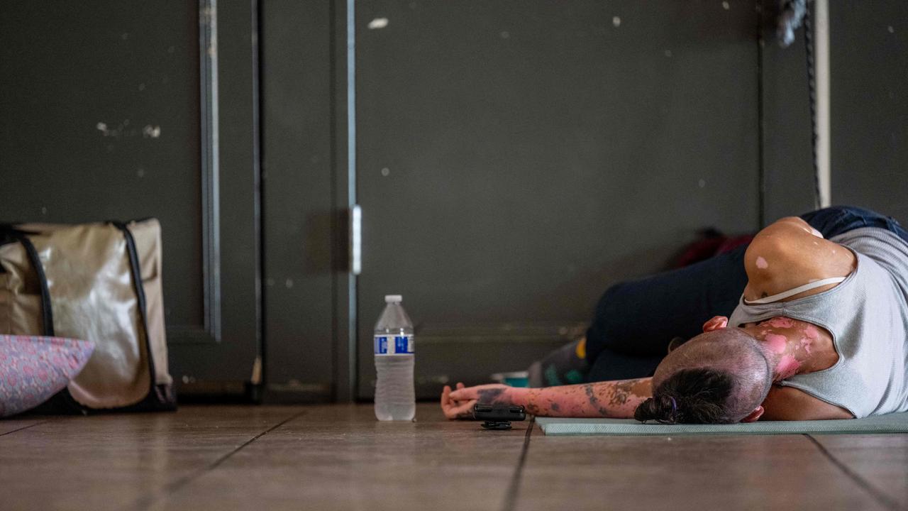 A person lays on the floor while seeking shelter from the heat on July 14 in Phoenix, Arizona. Picture: Brandon Bell