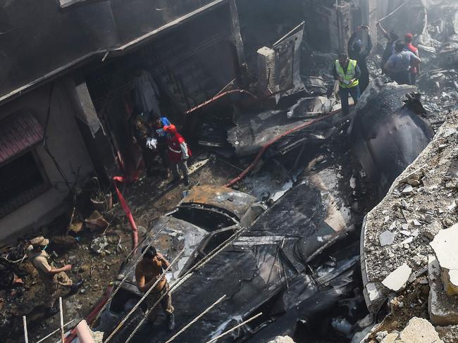 Rescue workers gather at the site after a Pakistan International Airlines aircraft crashed in a residential area in Karachi. Picture: AFP