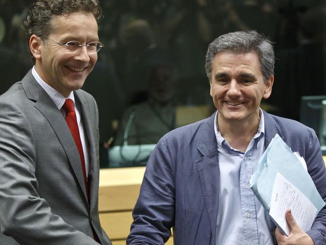 Seeking agreement ... Greek Finance Minister Euclid Tsakalotos, right, shakes hands with Dutch Finance Minister and chair of the eurogroup Jeroen Dijsselbloem as he flashes notes for his meeting. Picture: AP