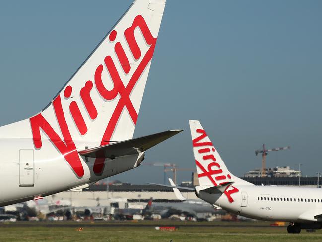 The Virgin Australia Holdings Ltd. logo is displayed on the tails of a Boeing Co. 737-800, left, and a Boeing Co. 737-8FE aircraft preparing to take off at Sydney Airport in Sydney, Australia, on Monday, Feb. 8, 2016. Virgin Australia is scheduled to announce half-year earnings on Feb. 11. Photographer: Brendon Thorne/Bloomberg