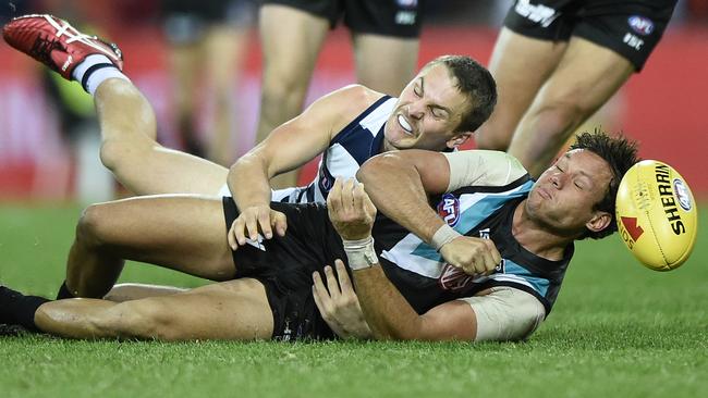 Geelong’s Tom Atkins brings down Steven Motlop.