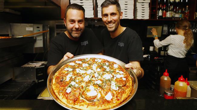 Cugini co-owners Marco Giusti, left, and Alfonso Giusti with a family-sized Caponata pizza, featuring eggplant, capsicum, fresh tomato, onion, ricotta, basil, garlic and cheese. Picture: MATT THOMPSON