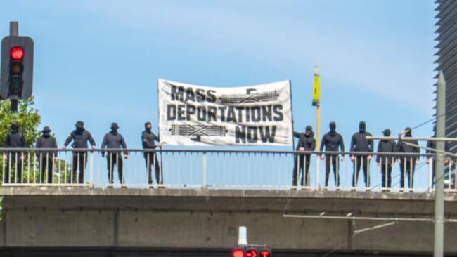 The group of masked protesters on the Morphett St bridge in Adelaide on Saturday. Picture: 7NEWS