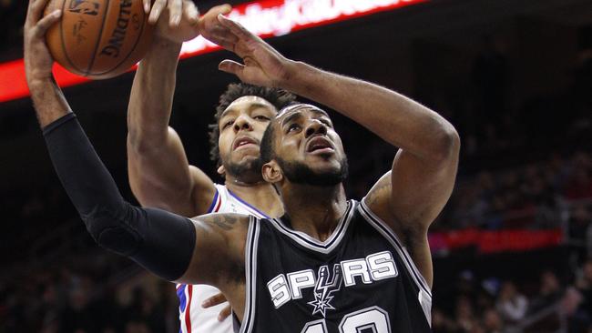 San Antonio Spurs' LaMarcus Aldridge, right, goes up for the shot as Philadelphia 76ers' Jahlil Okafor, left, reaches from behind and will draw the foul during the first half.