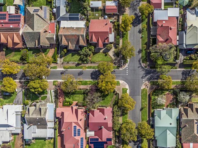 Aerial view of leafy eastern suburban houses on 4-way cross road intersection in Adelaide, South Australia: directly above, rooftop solar, trees. Housing property generic