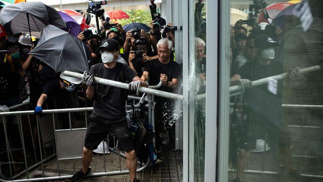 Pro-democracy politician Leung Yiu-chung tries to stop a protester from breaking a window at the government headquarters in Hong Kong. Picture: AFP