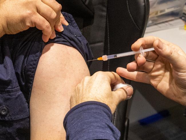 MELBOURNE, AUSTRALIA - JULY 11: A pharmacist administers a COVID-19 vaccination booster shot to a customer at Exhibition Pharmacy on July 11, 2022 in Melbourne, Australia. More Australians are now eligible to receive a fourth dose of a COVID-19 vaccine, after the Australian Technical Advisory Group on Immunisation (ATAGI) approved people aged 30 and above can access additional booster shots from Monday 11 July. While over 30s are now eligible for an additional dose if they choose, health authorities are strongly urging people over 50 to get the fourth COVID-19 vaccine booster and for people to wear masks indoors in public as coronavirus infections continue driven by Omicron subvariants. (Photo by Asanka Ratnayake/Getty Images)