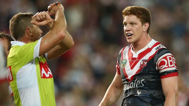 Referee Ben Cummins places Dylan Napa of the Roosters on report.