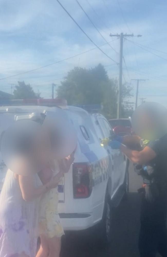 An officer points what looks to be a taser at two unknown women. Photos: Supplied.