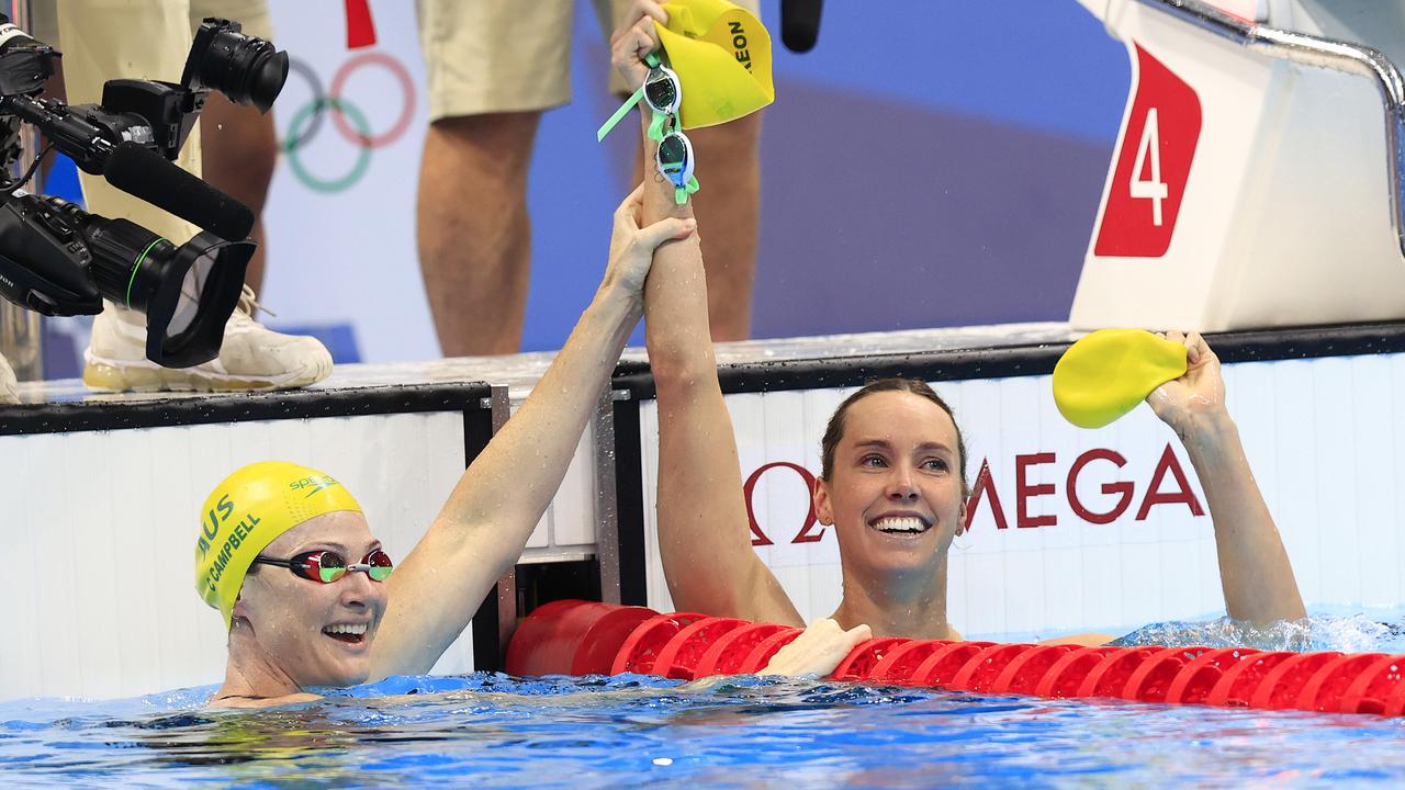 Cate Campbell holds Emma McKeon’s arm aloft post-race.