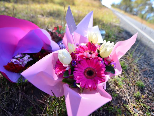 Flowers on the roadside mark the scene of a fatal crash.