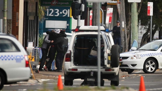 Two hostages carry the injured gunman from The Lakes Hotel in 2009.