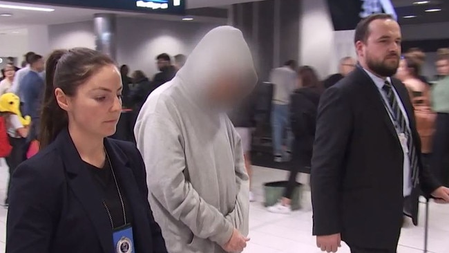 NSW police and Federal Police escorting a man through Sydney Airport after he was arrested in WA for several outstanding sexual assault warrants. Picture: Julian Andrews