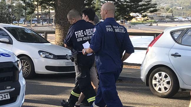 Sean Maguire is helped to an ambulance by emergency personnel after he and his friend fell close to 3 metes on to rocks at the base of Dee Why Headland.