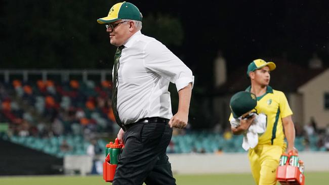 Then Prime Minister Scott Morrison runs drinks during the Prime Minister’s XI versus Sri Lanka T20 cricket match at Manuka Oval in 2019.