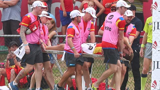 Gold Coast’s Sam Day is stretchered from the field during last year’s JLT Community Series match against Brisbane after dislocating his hip. Picture: Chris Hyde (Getty Images).