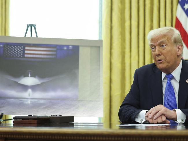 President Donald Trump speaks as an image of an F-47 sixth-generation fighter jet is displayed during an event in the Oval Office of the White House in Washington, Friday, March 21, 2025. (Pool via AP)