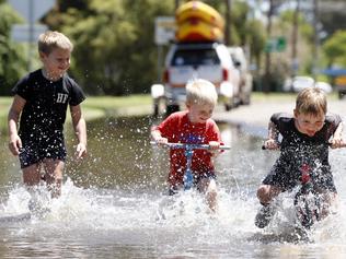 DAILY TELEGRAPH NOVEMBER 17, 2021. From left Cheyse Hoy, 6, brother Jaxon Hoy, 4, and friend Mack Acheson, 4, playing in the flood waters of the Lachlan River at the Forbes Iron Bridge Picture: Jonathan Ng