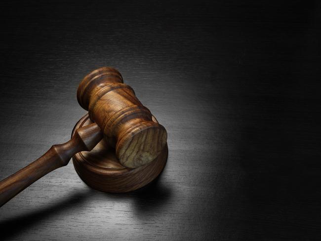 Real Judges Or Auctioneer Gavel Made From Walnut Wood On The Black Wooden Table In Spot Light, Top View, Close-up