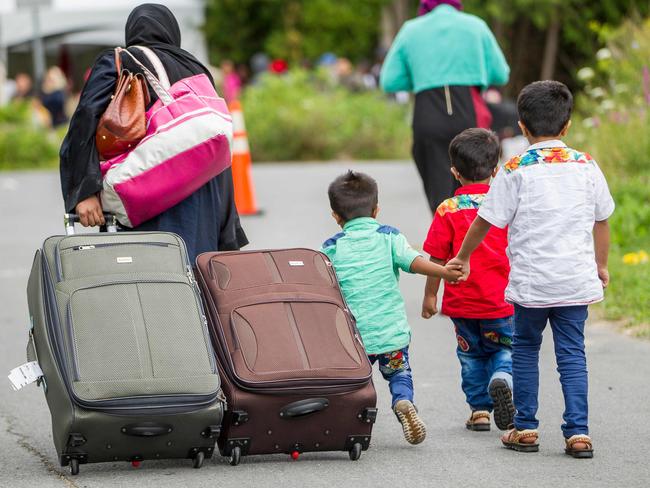 TOPSHOT - Asylum seekers walk along Roxham Road near Champlain, New York on August 6, 2017, making their way towards the Canada/US border. In recent days the number of people illegally crossing the border has grown into the hundreds. / AFP PHOTO / Geoff Robins