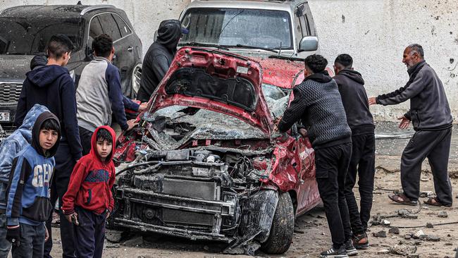 Men and youths gather to inspect a destroyed vehicle following overnight Israeli bombardment at the Rafah refugee camp. Picture: AFP