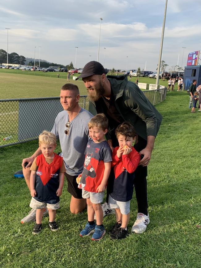 Melbourne players Adam Tomlinson and Max Gawn pose for photos with young fans.