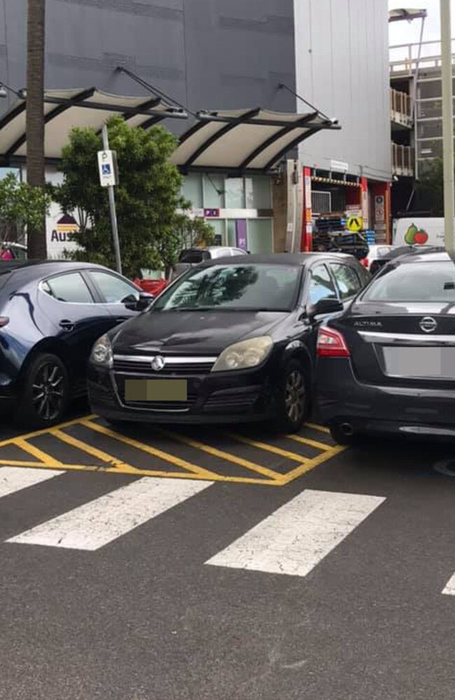 Someone shared this photo of a car that had parked between two disabled bays on a striped area, sparking fury. Picture: Facebook