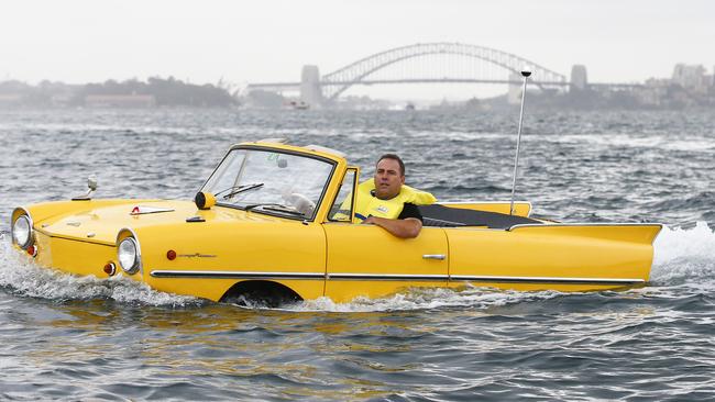 Jason Fischer, Operations Manager and Head Mechanic at Gosford Classic Car Museum, drives the 1966 Amphicar 770, the only commercially successful vehicle in the world that went from land to water, from Rose Bay boat ramp. Picture: Dylan Robinson