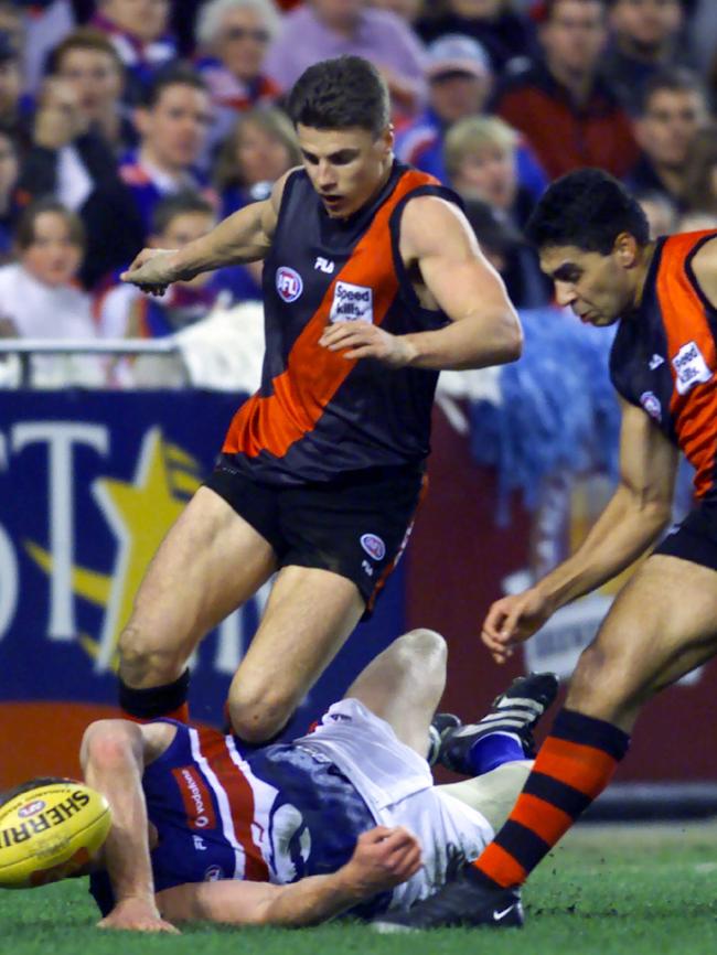 Chris Grant takes a tumble under pressure from Matthew Lloyd and Dean Rioli.