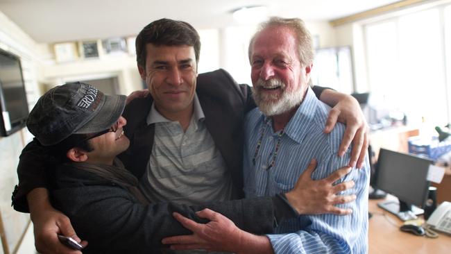 Shah Marai, centre, embraces colleagues Massoud Hossaini and Lawrence Bartlett after Hossaini won the Pulitzer Prize, at the AFP office in Kabul. Picture: AFP