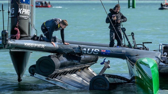 Tom Slingsby looks over the damage sustained to the F50 a finish line marker in Christchurch. Photo: Ricardo Pinto for SailGP.