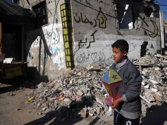 A young boy carries a lantern as he walks in war-devastated neighbourhood, ahead of the Muslim holy fasting month of Ramadan, in Khan Yunis in the southern Gaza Strip. Picture: AFP