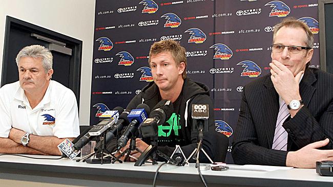 Nathan Bock sits stone-faced at his ''farewell'' between Adelaidecoach Neil Craig and chief executive Steven Trigg. Picture: Ray Titus