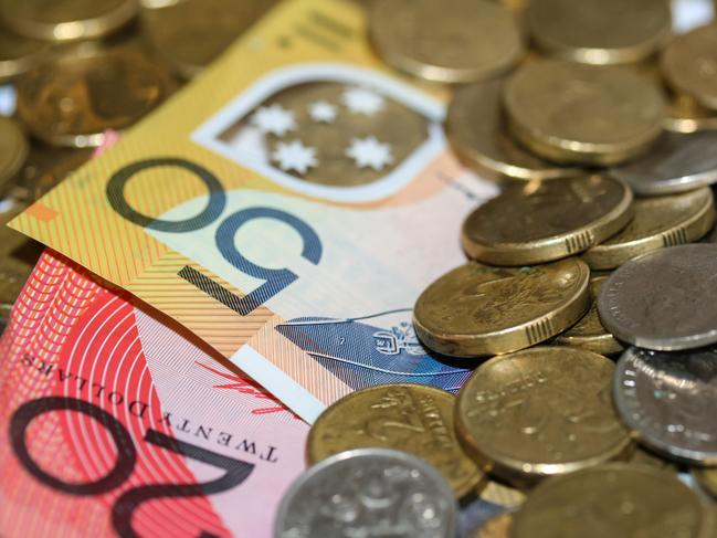 Close up of Australian money, twenty and fifty dollar notes and gold and silver coins scattered on pile.