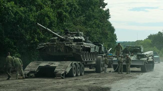 Ukrainian soldiers load an abandoned Russian military vehicule on a trailer in Kharkiv region. The armour and weapons left behind disavowed any idea of an orderly redeployment. Picture: General Staff of the Ukrainian Armed Forces / AFP