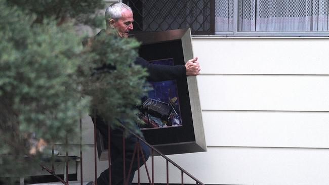 Russell Lutton taking the painting out of a house in Kingston. Picture: AAP image, John Gass