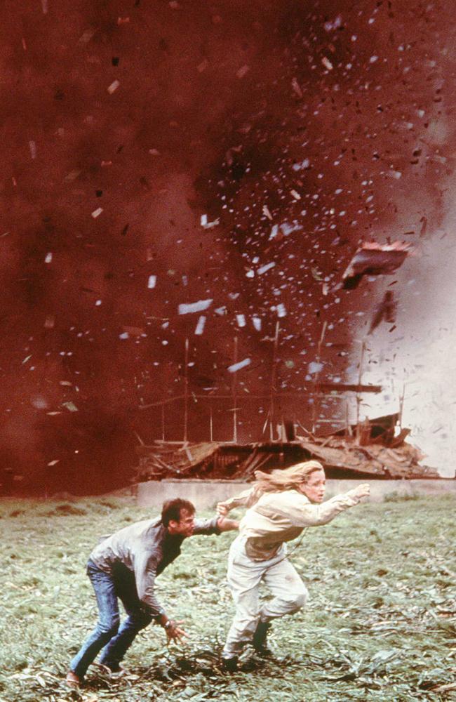 Bill Paxton and Helen Hunt run from an oncoming tornado in a scene from Twister.