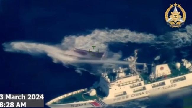 A still from aerial video footage shows a China Coast Guard ship using water cannon against a Philippine boat during a clash in March.